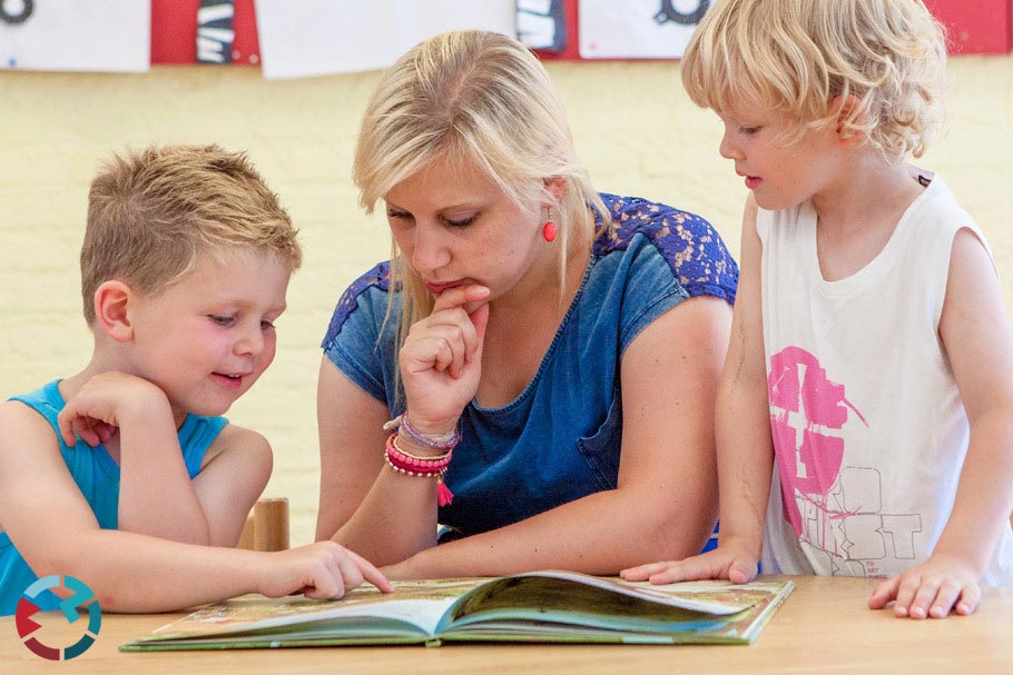 Juf leest samen met twee kinderen een boek zakelijke shoot