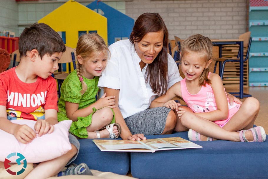 Juf leest met 3 kinderen op de grond zakelijke bedrijfsfotografie in Tilburg en Brabant