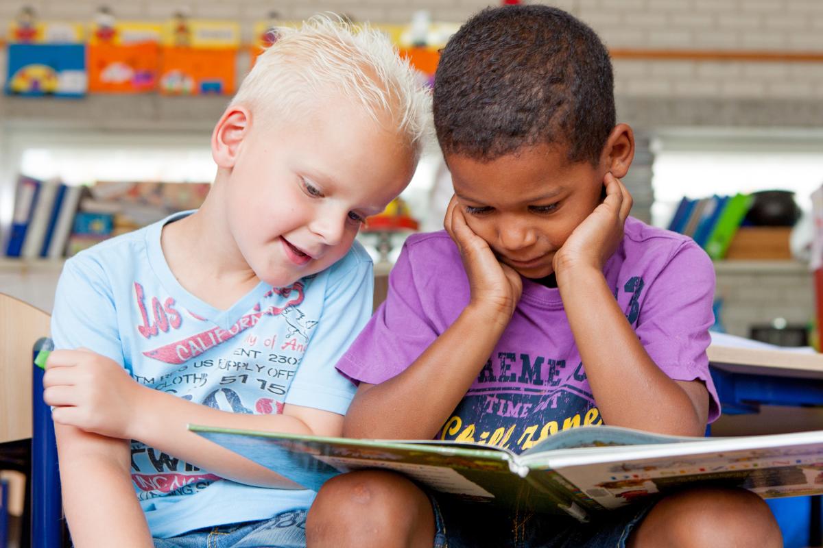 Blonde_en_donkere_jongen_lezen_samen_in_een_kleuterklas_een_boek.
