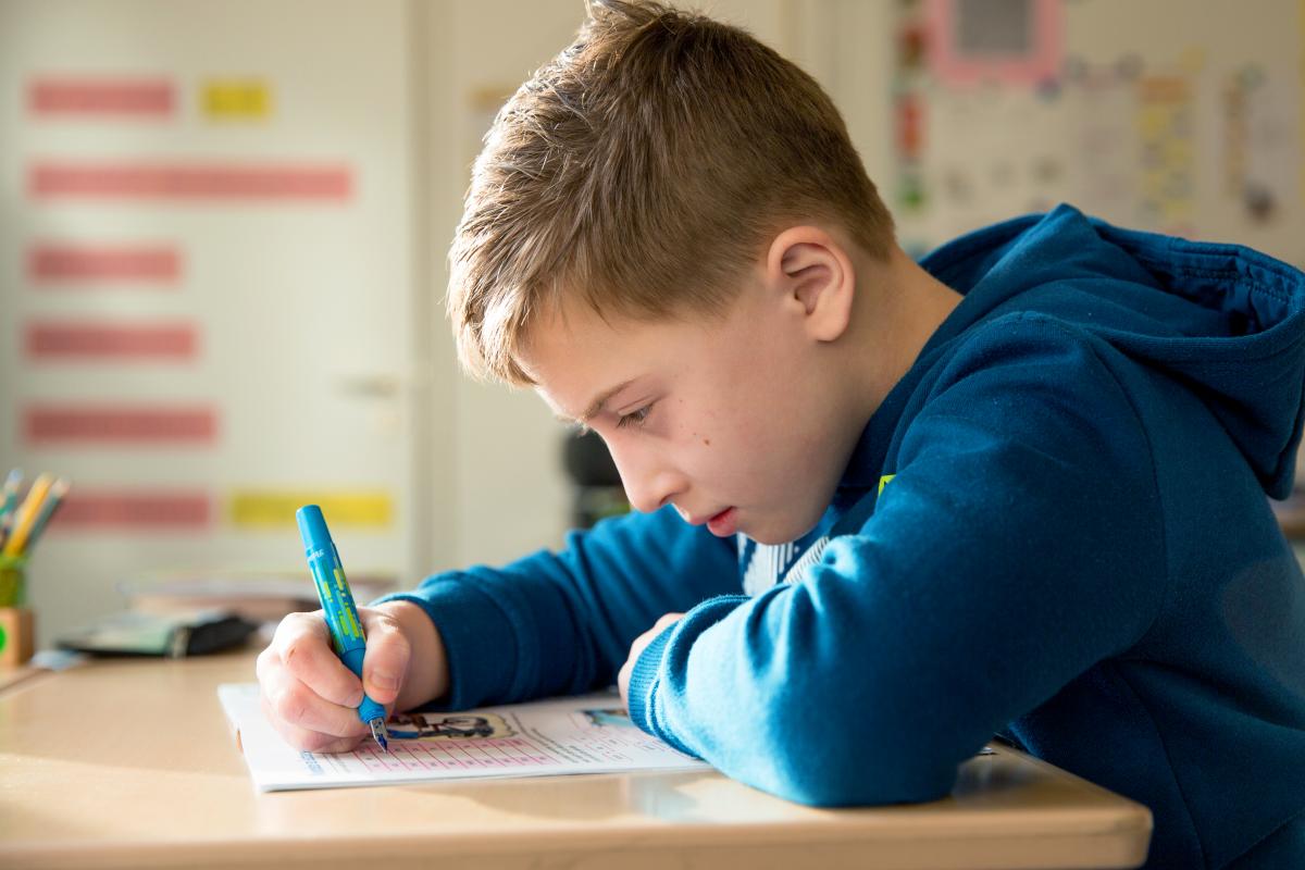 Jongen_uit_groep_6_werkt_in_de_klas_in_zijn_werkboek.